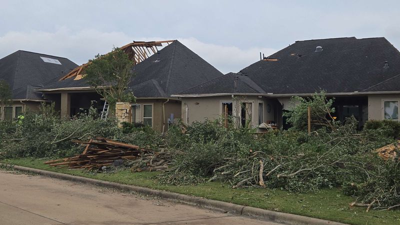 Downed trees and roof damage on a Cypress, TX street after a 2024 tornado