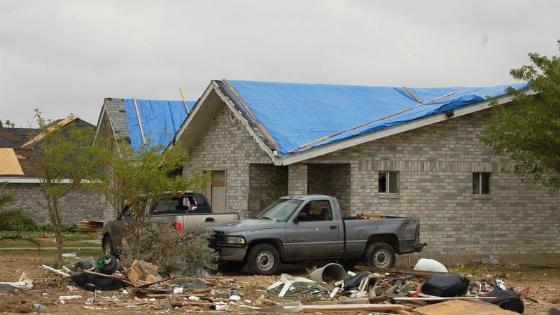 Blue tarps on storm-damaged brick homes in Texas