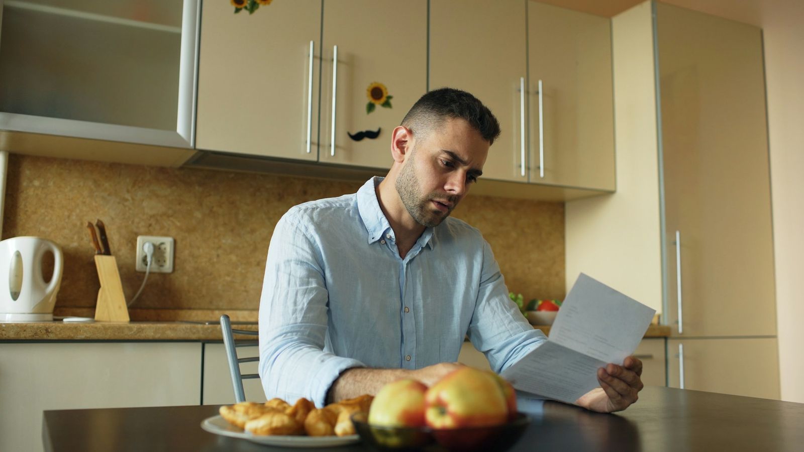 Homeowner reading a letter at the kitchen table