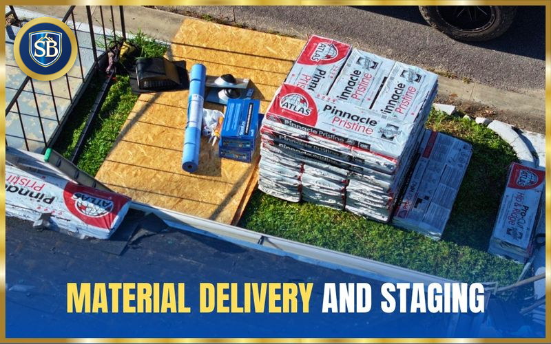 Shingle bundles, underlayment, and roofing supplies staged neatly on protective boards beside the driveway — material delivery and staging