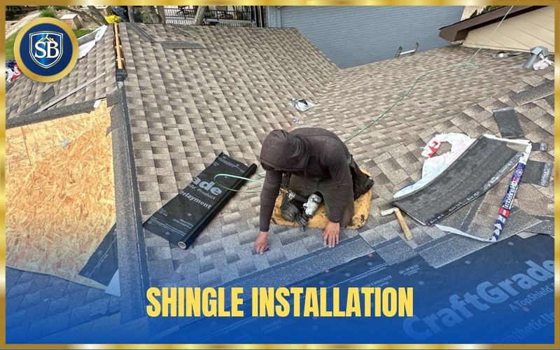 Roofer fastening new architectural shingles with a nail gun during a roof replacement — shingle installation